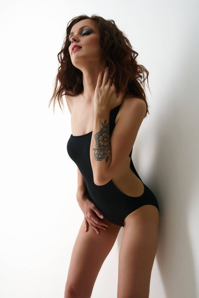 Erotica. Sensual brunette posing in black bodysuit - Foto, Bild