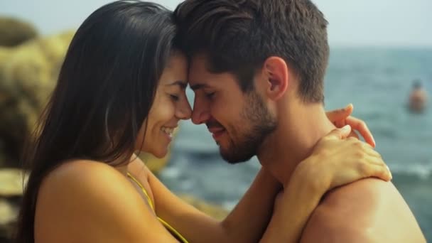 Szczęśliwy uśmiechający się para w Pływaniu garnitur, przytulanie na pięknej plaży. - Materiał filmowy, wideo