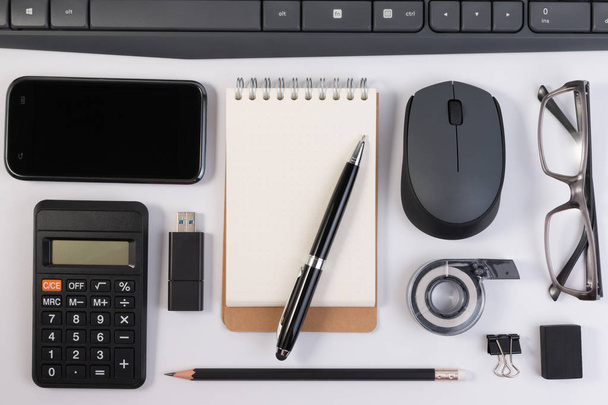 Forniture per ufficio, dispositivi informatici e notebook con penna sul posto di lavoro isolato su sfondo bianco
. - Foto, immagini