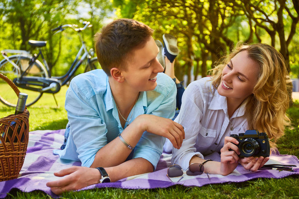 Couple using a compact photo camera at a picnic. - Photo, Image