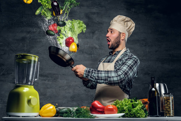 Kuchař, drží pánev se zeleninou - Fotografie, Obrázek