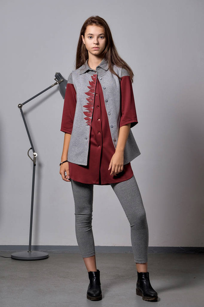 Pretty young fashion model in warm wool clothes posing near metal floor lamp - Foto, Imagen