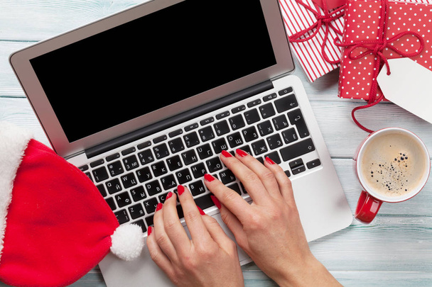 Female working on laptop and wrapping gifts - 写真・画像