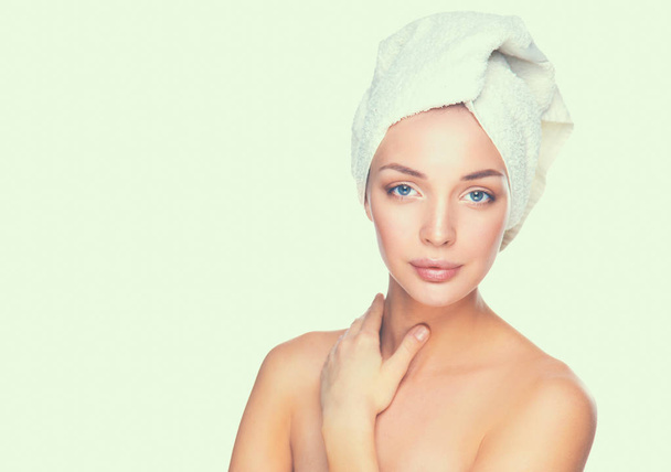 Portret van mooi meisje raakt haar gezicht met een handdoek op hoofd - Foto, afbeelding