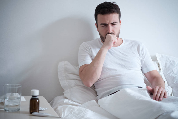  Uomo sentirsi male sdraiato sul letto e tossire
 - Foto, immagini