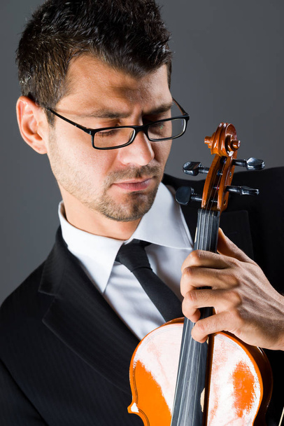 Músico com violino sobre fundo escuro
 - Foto, Imagem