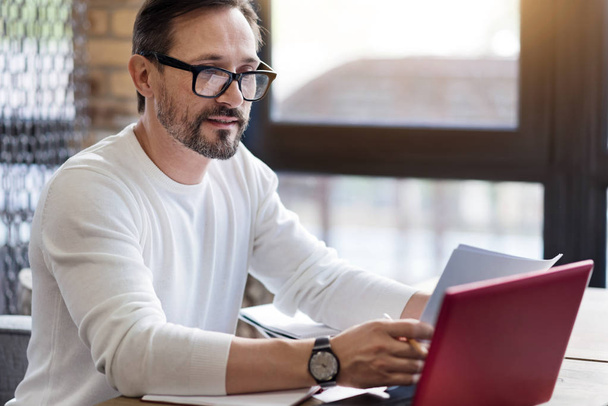 Bearded man with glasses working on laptop - Фото, зображення