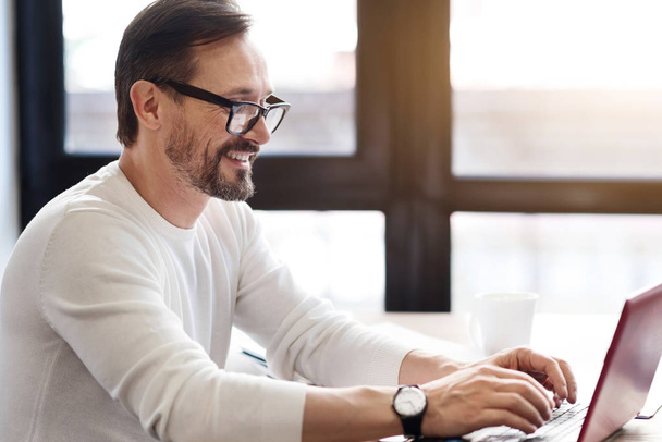 Bearded man with glasses working on laptop - Zdjęcie, obraz