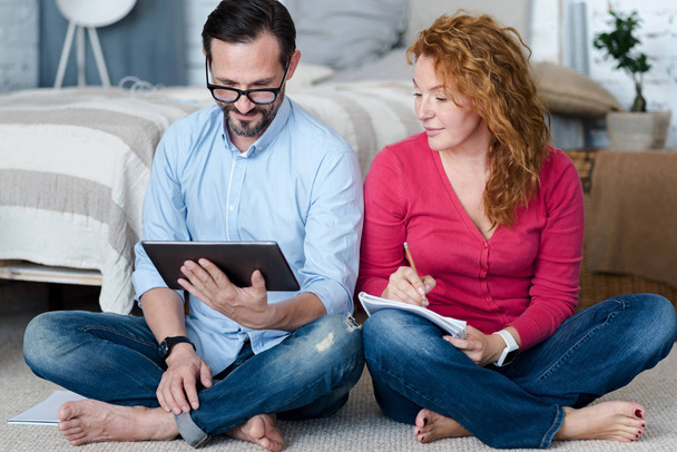 Middle-aged couple using tablet at home - Photo, image