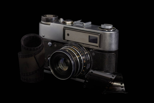 alte Fotokamera und Fotofilme auf dunklem Hintergrund - Foto, Bild