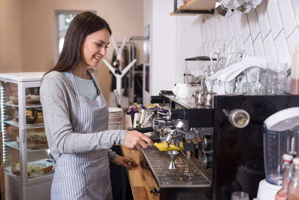Smiling beautiful woman using coffee machine - Zdjęcie, obraz