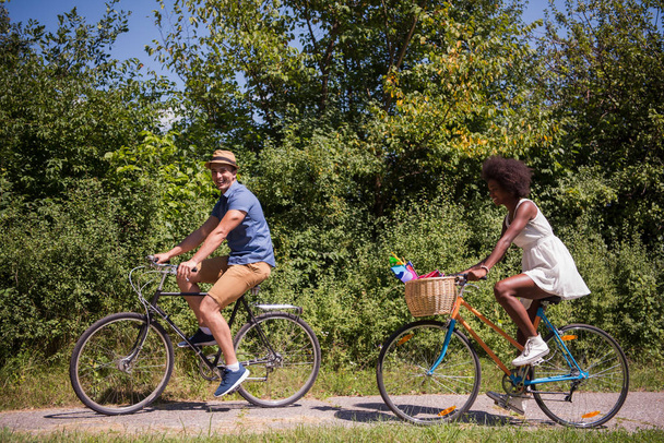 Neşeli Bisiklet sahip genç bir çift doğada binmek - Fotoğraf, Görsel