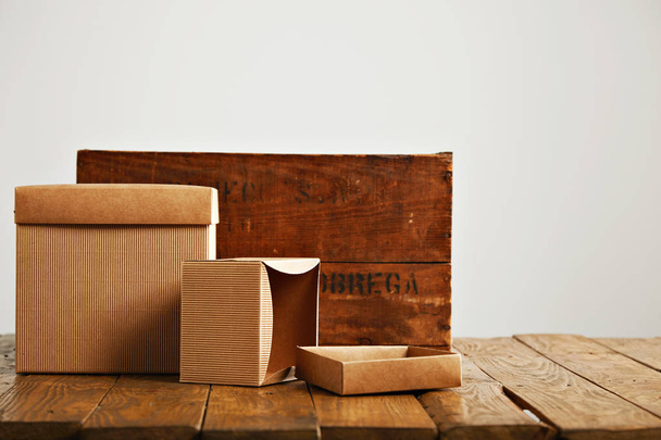 Blank corrugated cardboard boxes with vintage wooden box - Foto, afbeelding