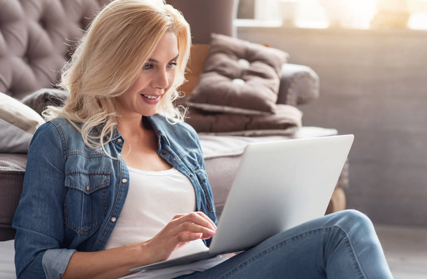 Blond woman working with laptop at home - Foto, afbeelding