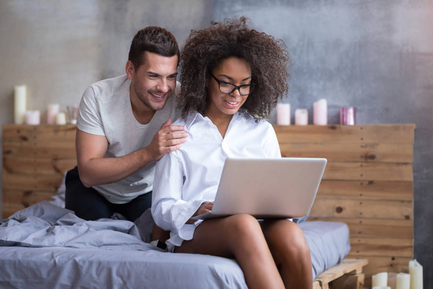 couple sitting in bed and using laptop - Φωτογραφία, εικόνα