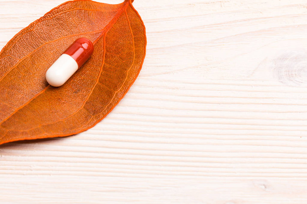 Pilule médicale blanche brune sur une seule feuille orange
 - Photo, image