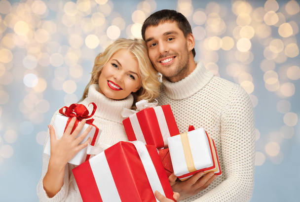 happy couple with christmas gifts over lights - Foto, Imagen