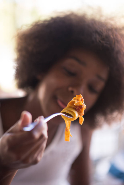 a young African American woman eating pasta - Fotografie, Obrázek
