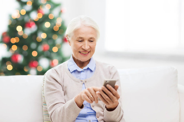 senior woman with smartphone texting at christmas - Zdjęcie, obraz