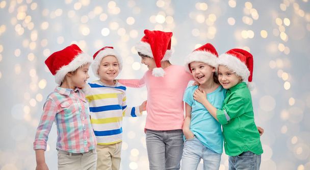 happy little children in santa hats hugging - 写真・画像