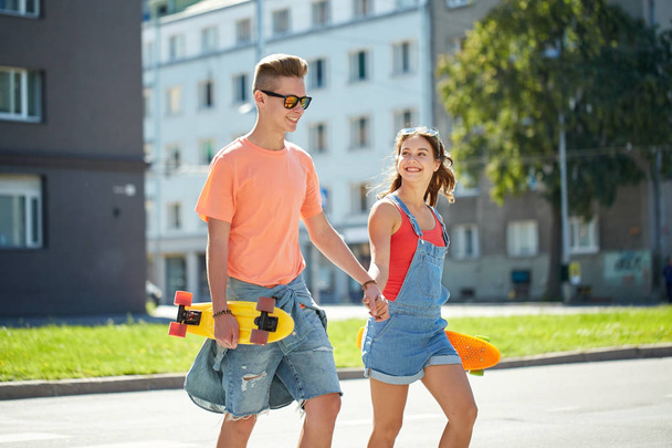 teenage couple with skateboards on city street - Fotoğraf, Görsel