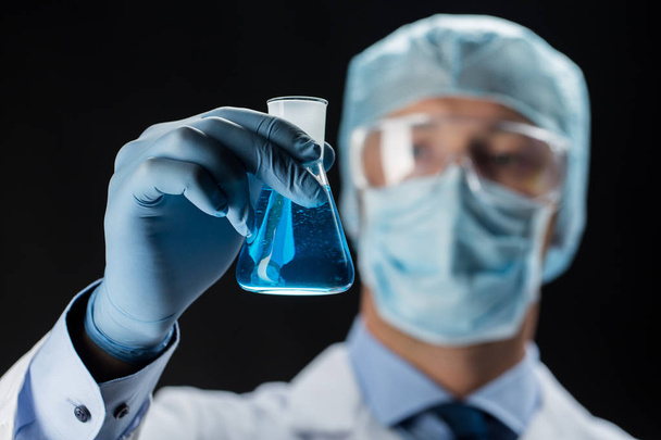 close up of scientist holding flask with chemical - Foto, Bild