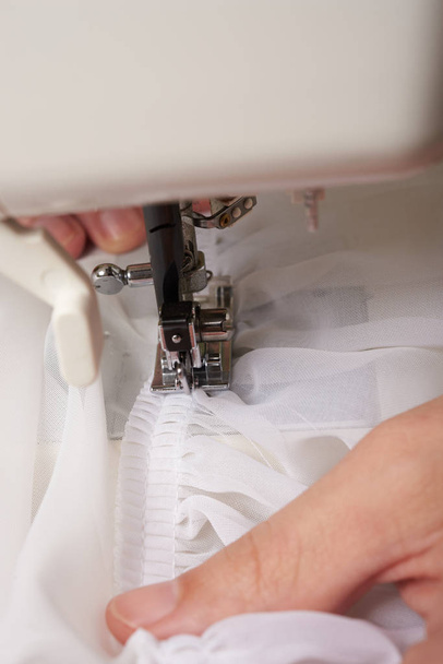 Mujer roscando en la máquina de coser
 - Foto, Imagen