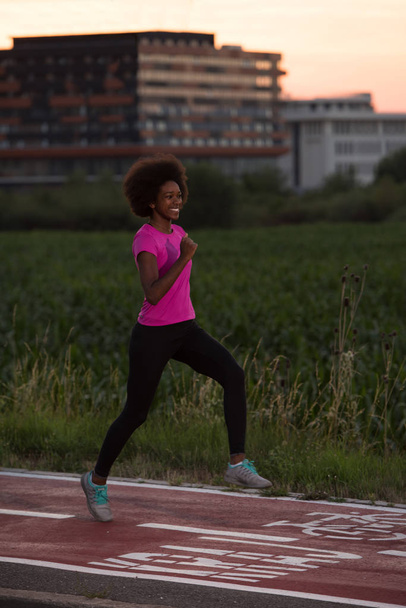 a young African American woman jogging outdoors - Foto, Imagem