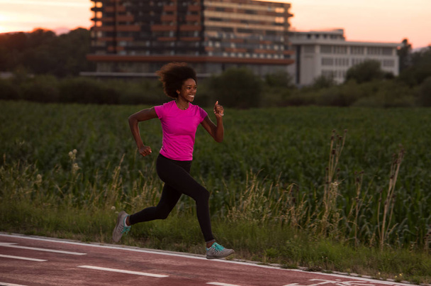 a young African American woman jogging outdoors - Photo, image
