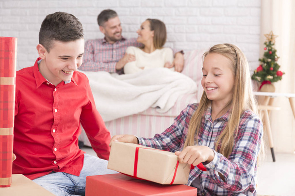 Sister and brother unwrapping gifts - 写真・画像