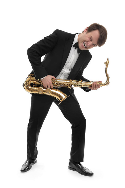 Saxofonist speelt saxofoon hardrock met een grappig gezicht. - Foto, afbeelding