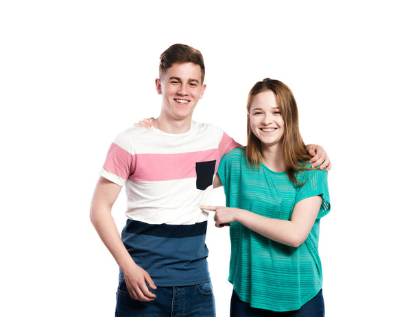 Teenage boy and girl, arms around each other, isolated. - Φωτογραφία, εικόνα