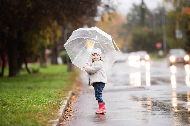 Little girl under the transparent umbrella outside, rainy day. - Foto, Bild