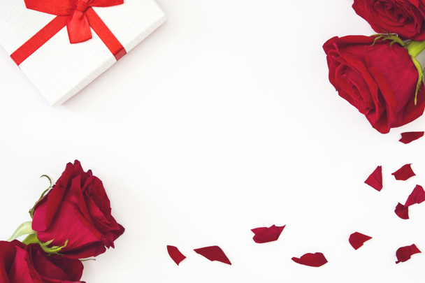 Белая подарочная коробка и красные розы на белом фоне
 - Фото, изображение