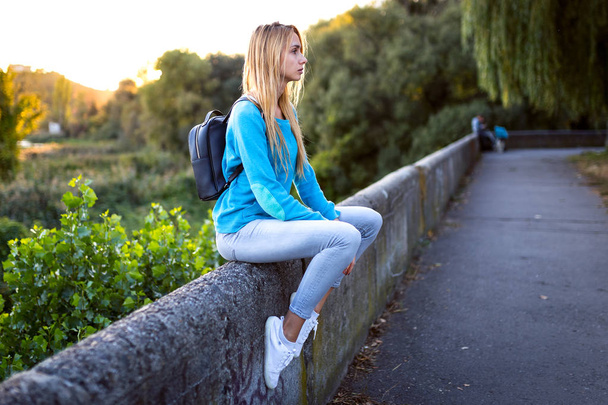 стильная девушка сидит с рюкзаком
 - Фото, изображение