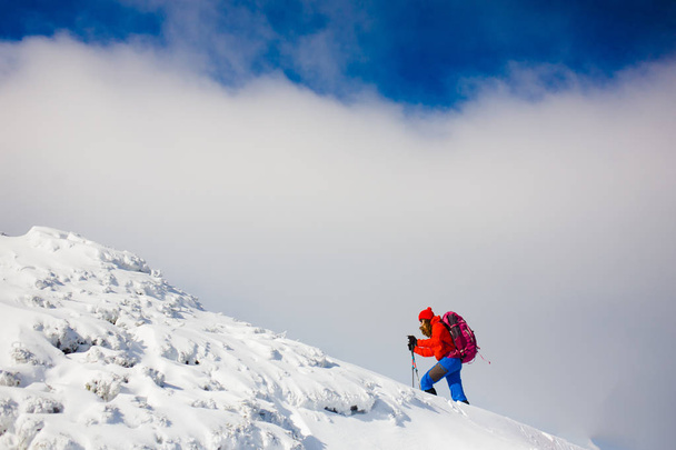 Climber with backpack walks on a snowy slope. - Photo, Image