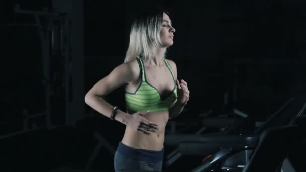 Çekici beyaz kız slowmotion içinde spor salonunda bir koşu bandı üzerinde çalışan - Video, Çekim