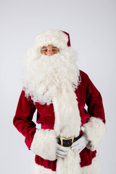 Noel Baba gözlük ve beyaz arka plan üzerinde duran ve kameraya bakarak kırmızı kostüm.  - Fotoğraf, Görsel