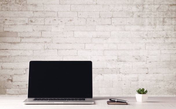 Business laptop with white brick wall - Φωτογραφία, εικόνα