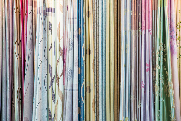 Muestras de cortinas de colores colgando de perchas en un riel en un dis
 - Foto, imagen