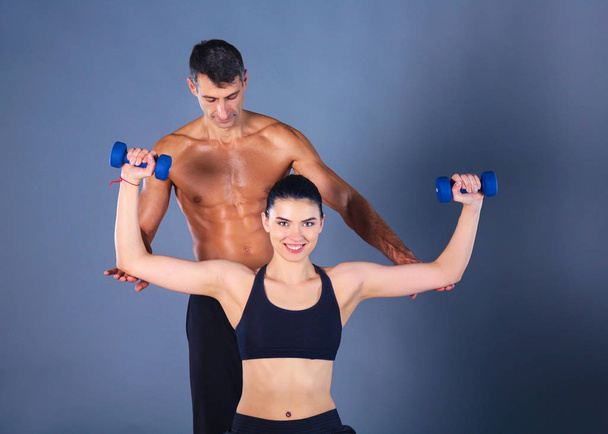 Atletische man en vrouw met een dumbells - Foto, afbeelding