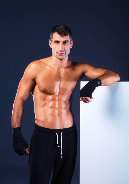 muscular man holding blank - Foto, imagen