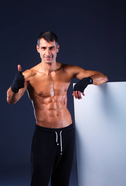 muscular man holding blank - Фото, зображення