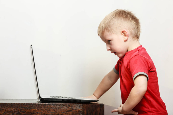 Little boy with laptop on table in home. - Fotoğraf, Görsel