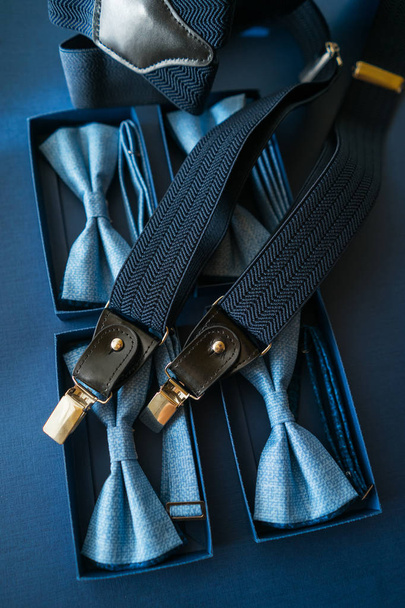 Ανδρική φορεσιά αξεσουάρ τόξο γραβάτα και ζαρτιέρες σε μπλε φόντο. - Φωτογραφία, εικόνα
