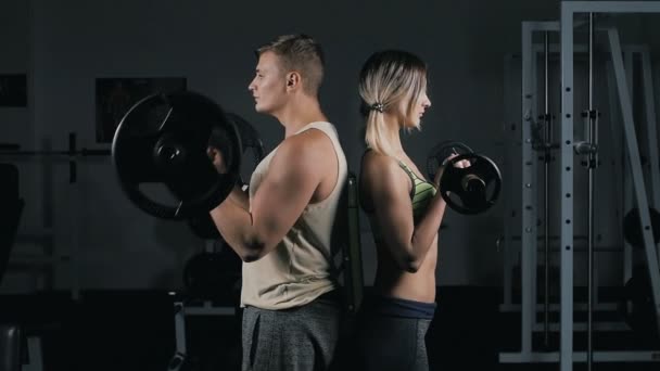 Sportos pár férfi és a nő csinál súlyzó fürt - Felvétel, videó