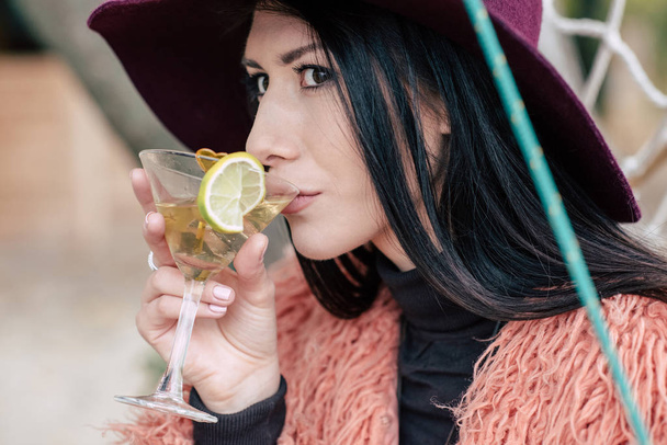 Fashionable young woman drinking cocktail - Фото, изображение