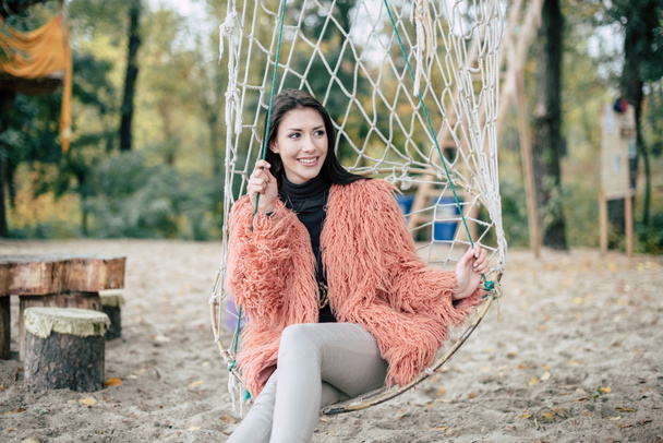 Attractive woman sitting in net swing - Photo, Image