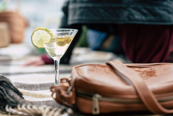 Martini in vetro e borsetta su plaid a quadri
 - Foto, immagini