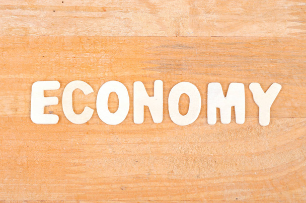 Palavra de economia sobre fundo de madeira
 - Foto, Imagem